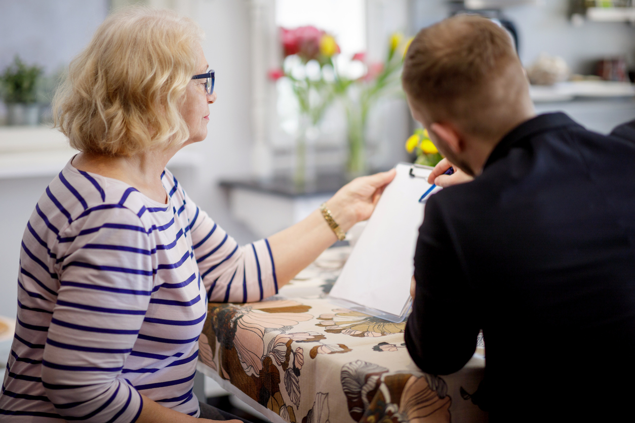 Mutter und Sohn sitzen am Tisch und erledigen Papierkram.