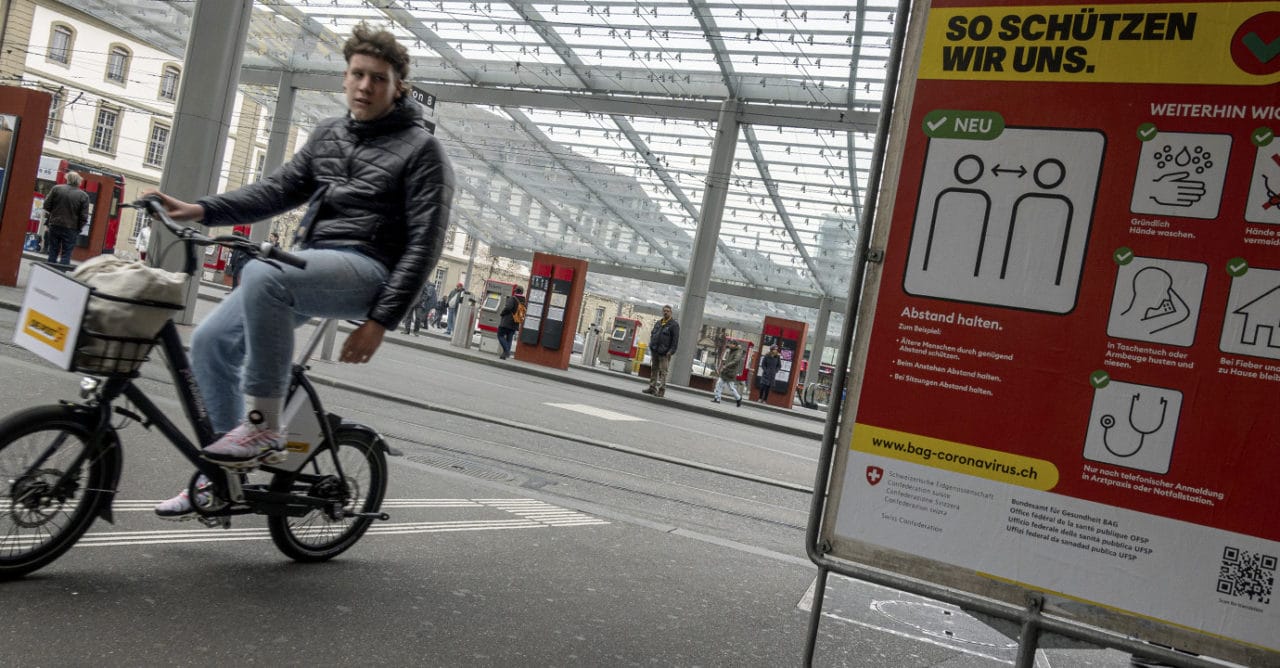 Corona-Zeit: junger Mann fährt mit dem Velo Lebenmittel durch die Stadt Bern